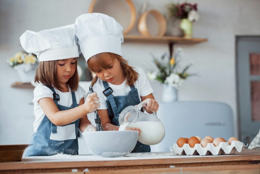 Two girls baking together, doing indoor activities for kids.