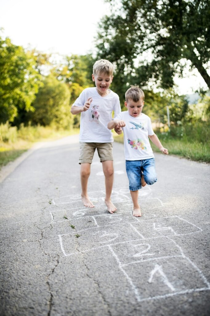 Two boys playing hopscotch outside
